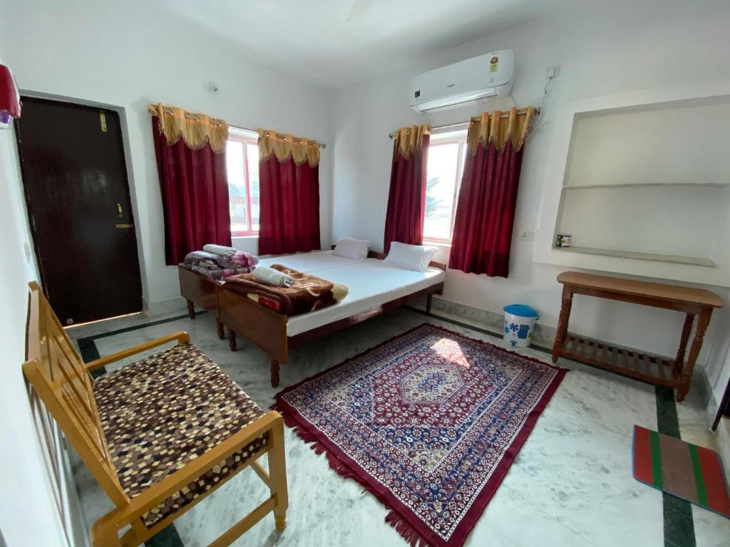 a room with a bed and a couch and a table at Rahul Guest House in Bodh Gaya