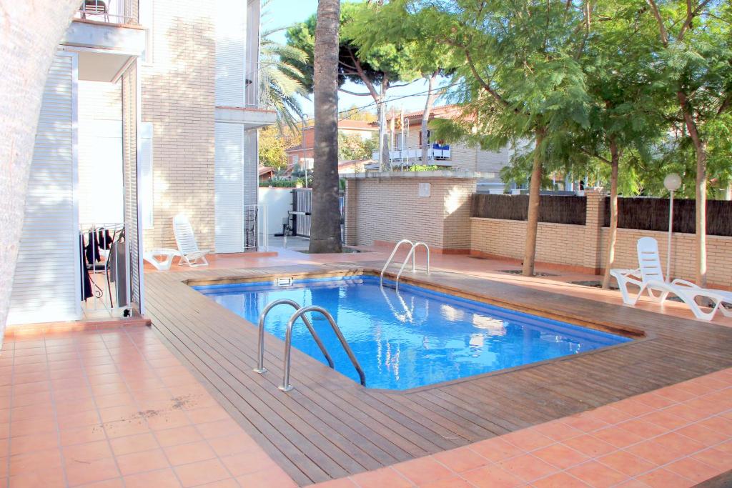 a swimming pool with a slide in the middle at Apartamentos Caru in Castelldefels