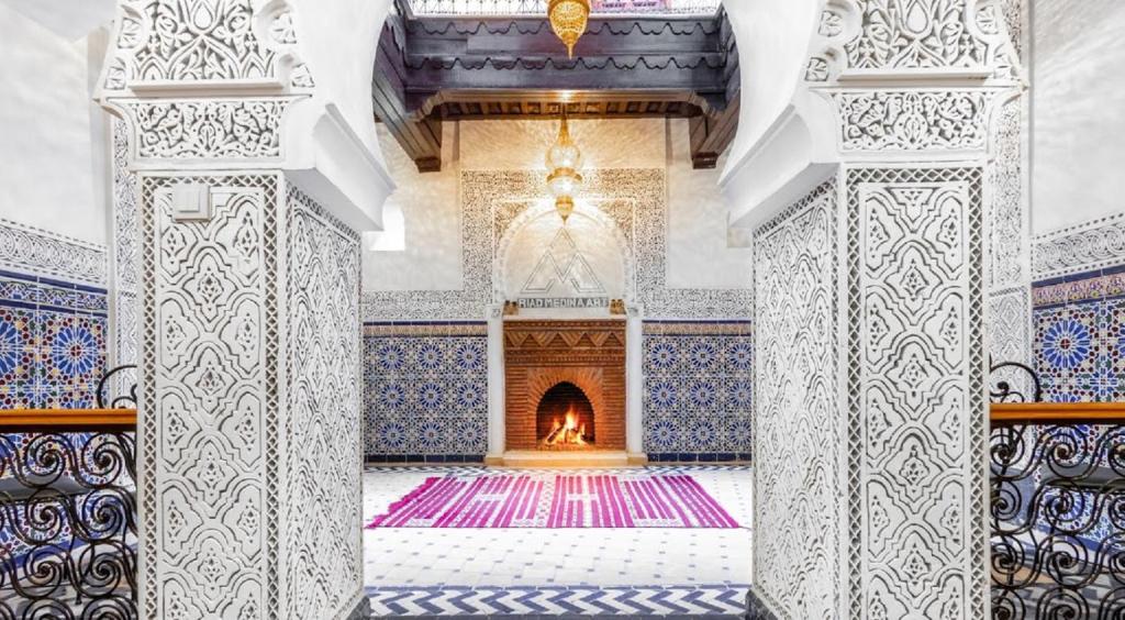 um quarto com lareira numa mesquita com azulejos azuis e brancos em Riad Medina Art & Suites em Marraquexe