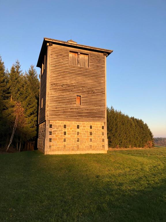a wooden building sitting on top of a grass field at Ferienwohnung Limespark am See in Rainau