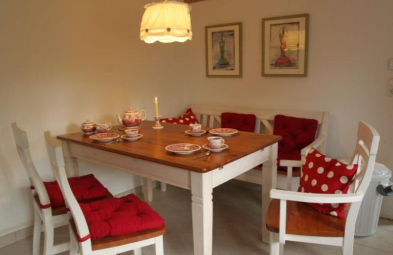 een eetkamer met een tafel en stoelen met een kaars bij Ferienhaus Deichgraf in Vollerwiek