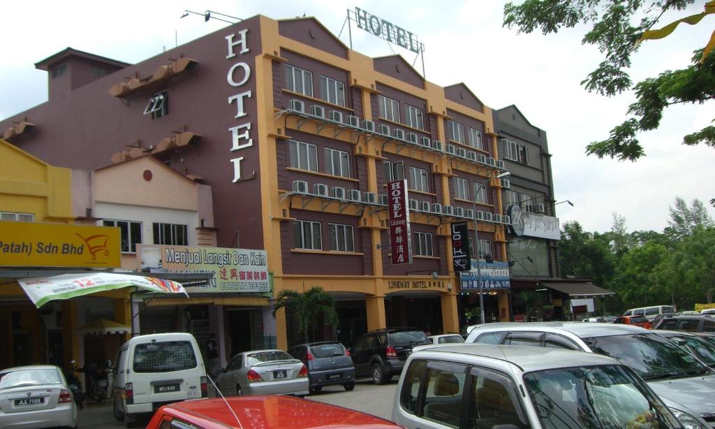 a large building on a city street with cars parked at Linkway Hotel in Nusajaya