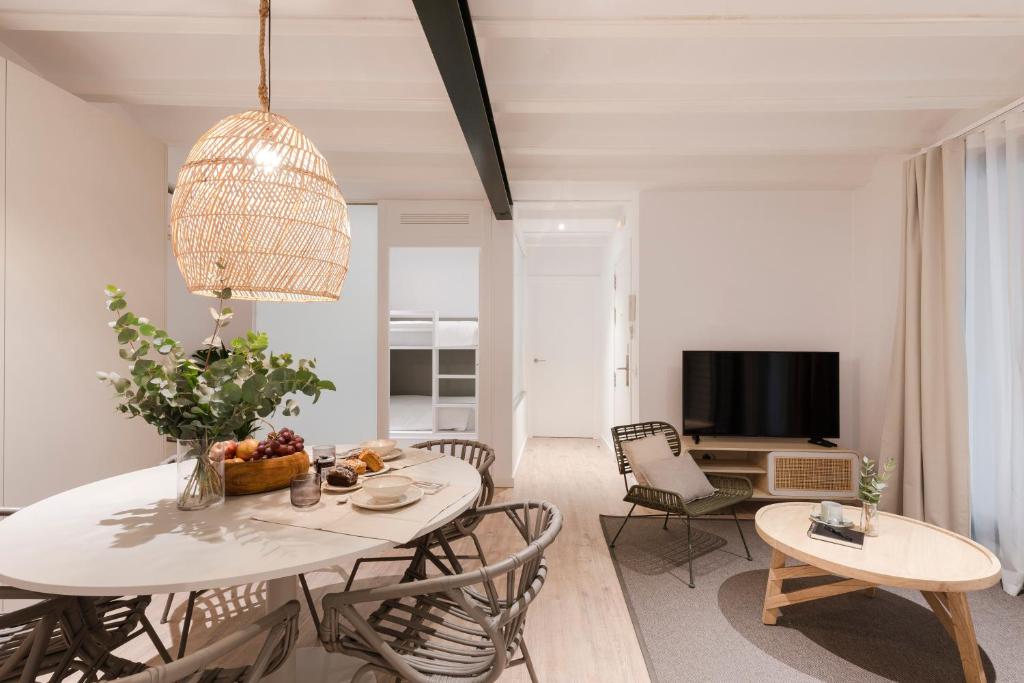 a living room with a white table and chairs at Aspasios Verdi Apartments in Barcelona