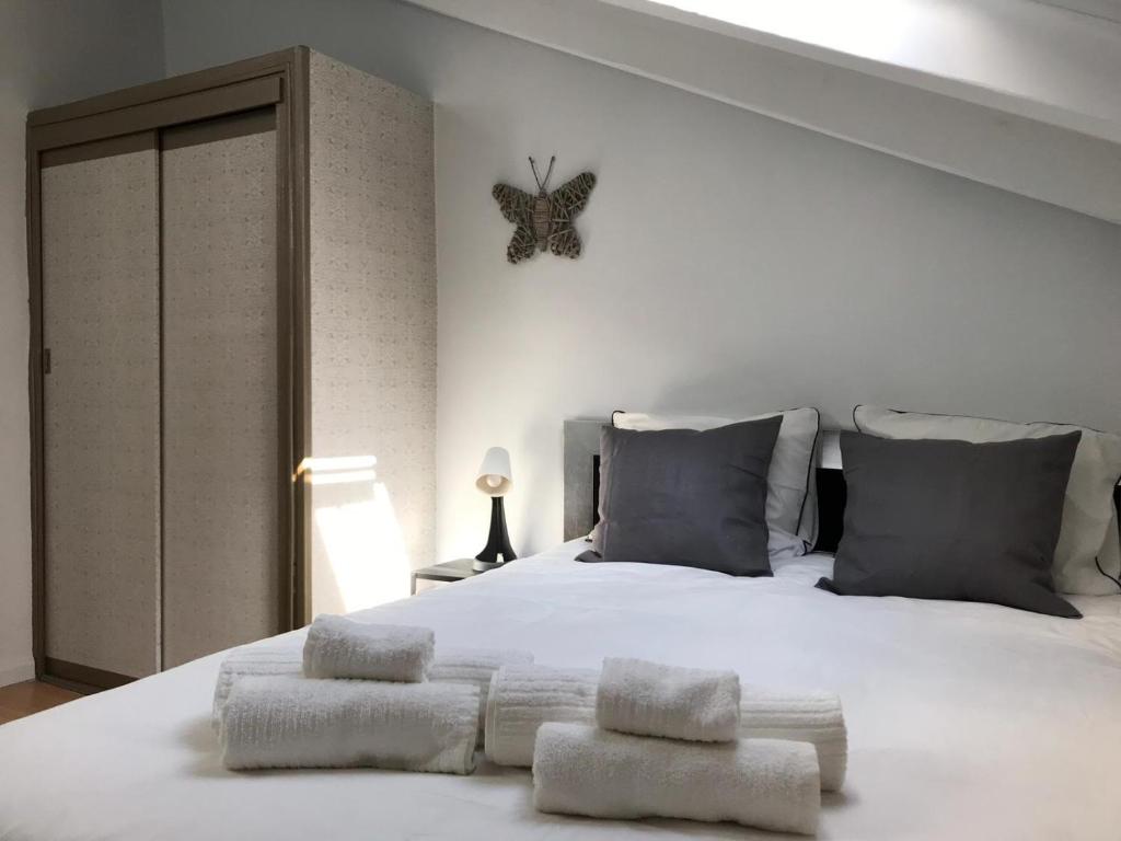 um quarto com uma cama branca com dois bancos em Apartment PALOMA em Madri