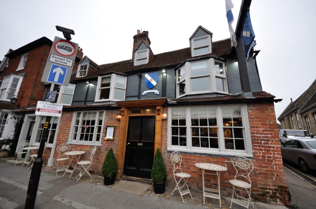 a building with tables and chairs on a street at The Marlborough in Marlborough