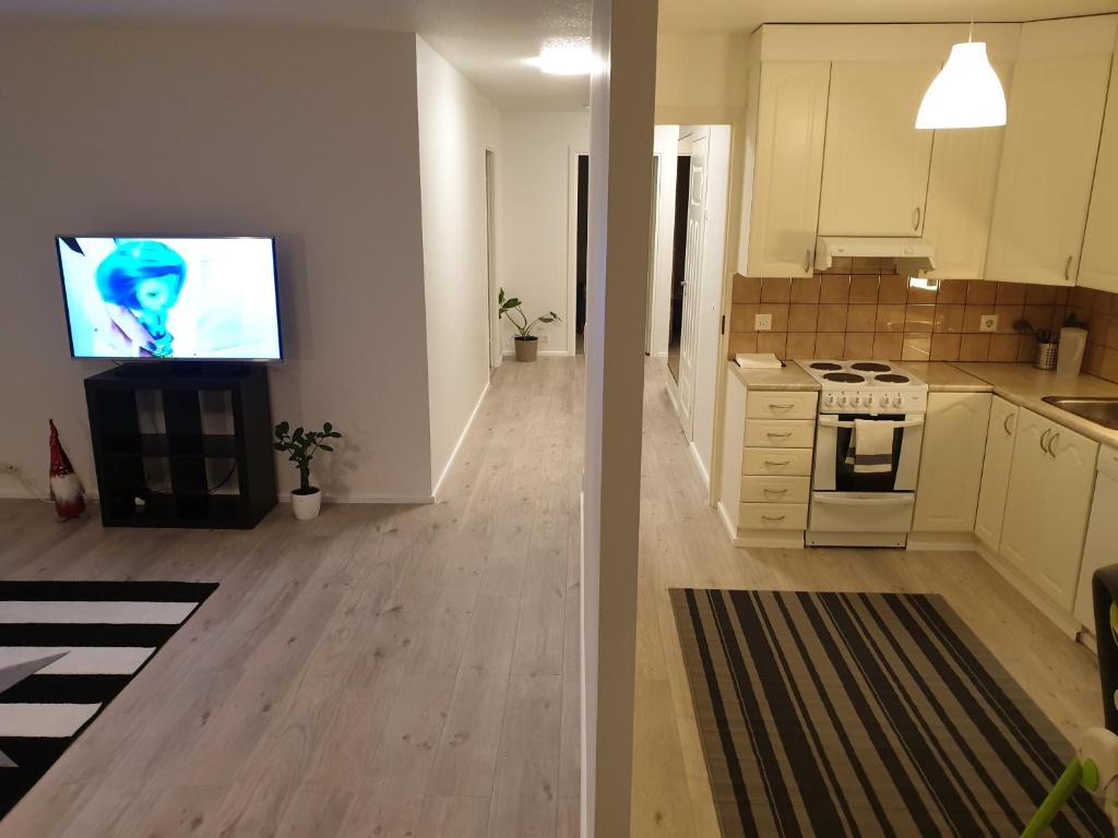 a kitchen and a living room with a tv in it at Easy and short from the airport in Helsinki