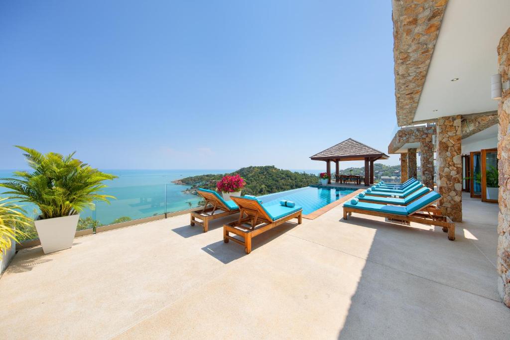 een villa met een zwembad met uitzicht op de oceaan bij Villa Syama in Koh Samui 