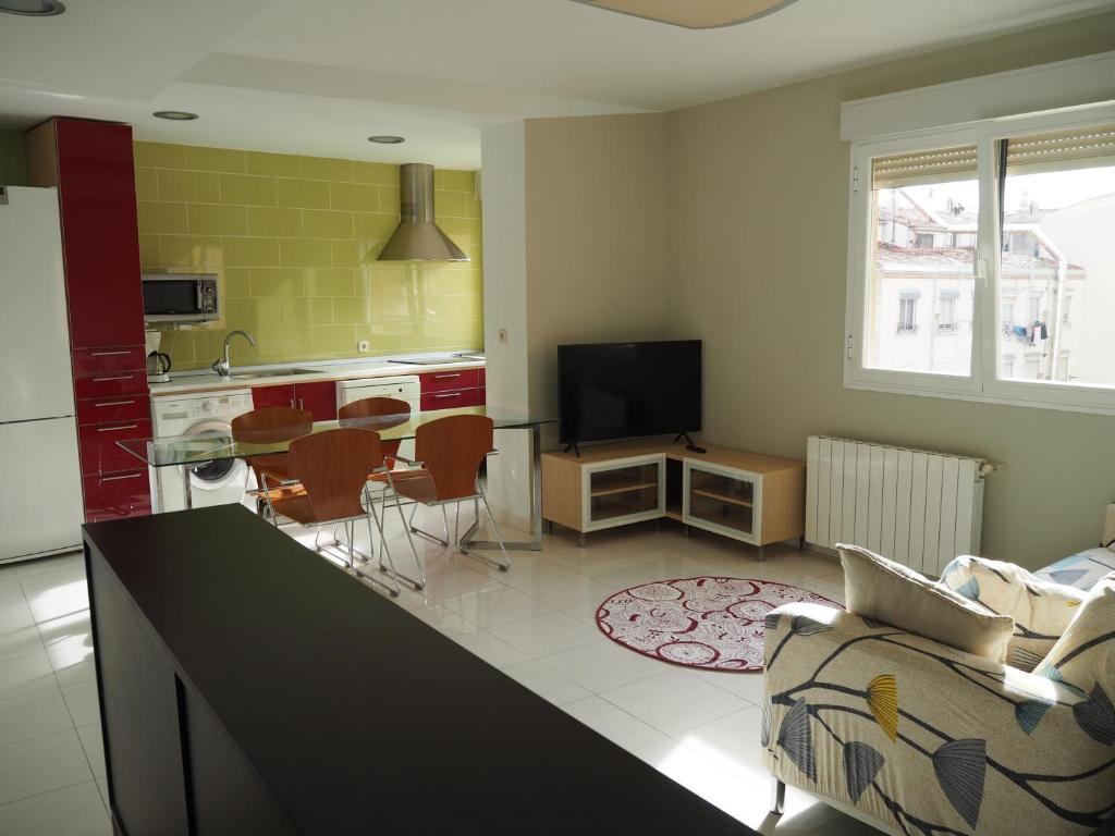 a kitchen and living room with a couch and a table at Apartamento El Ayuntamiento de Logroño in Logroño