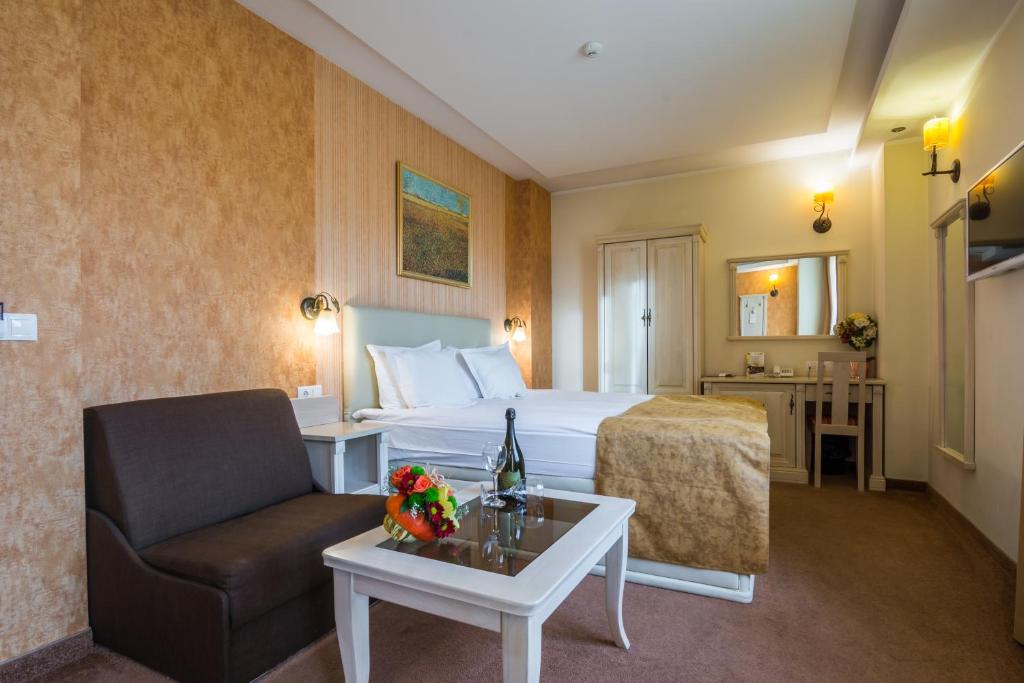 Habitación de hotel con cama, silla y mesa en Hotel Adria, en Sofía