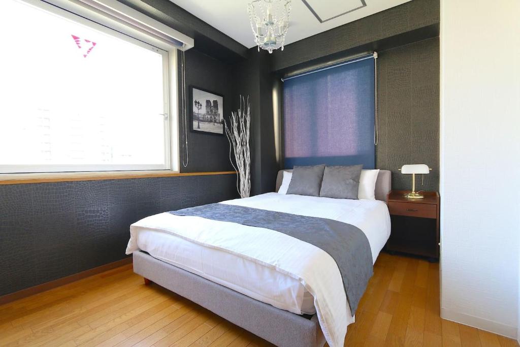 a bedroom with a large bed and a window at NM62 Liz Osaka Castle in Osaka