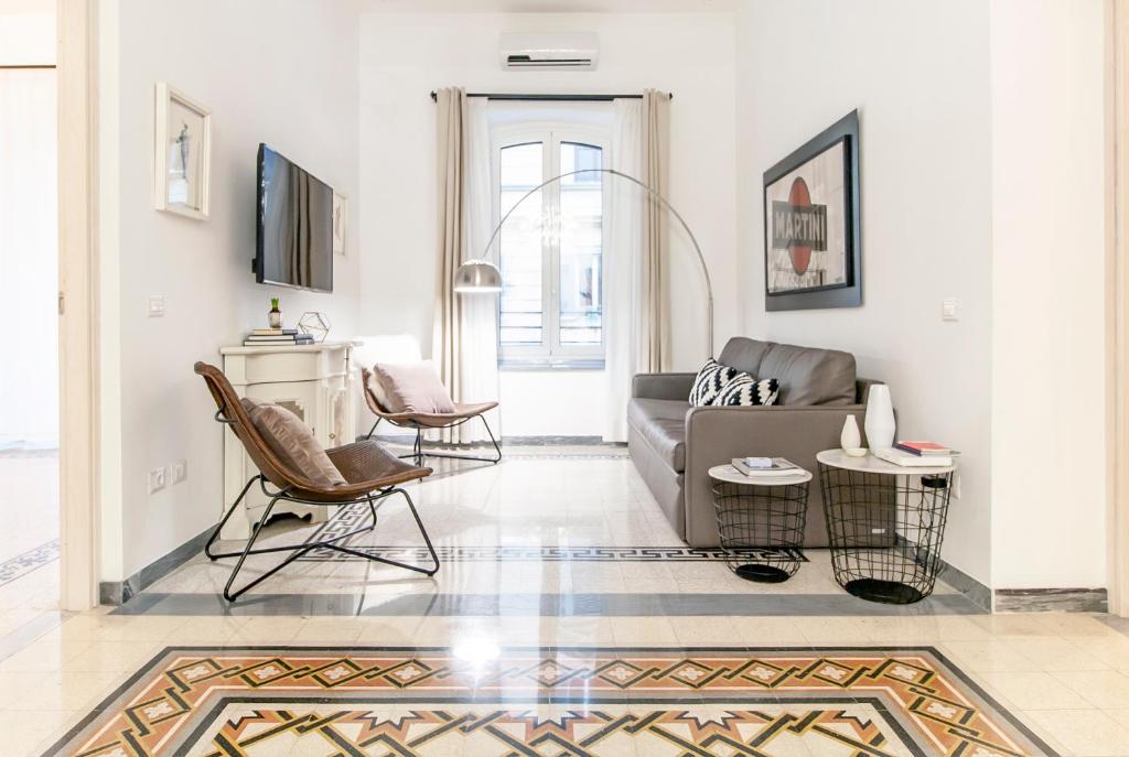 ein Wohnzimmer mit einem Sofa und Stühlen in der Unterkunft Modern Comfort, Poetic Charm in Rom