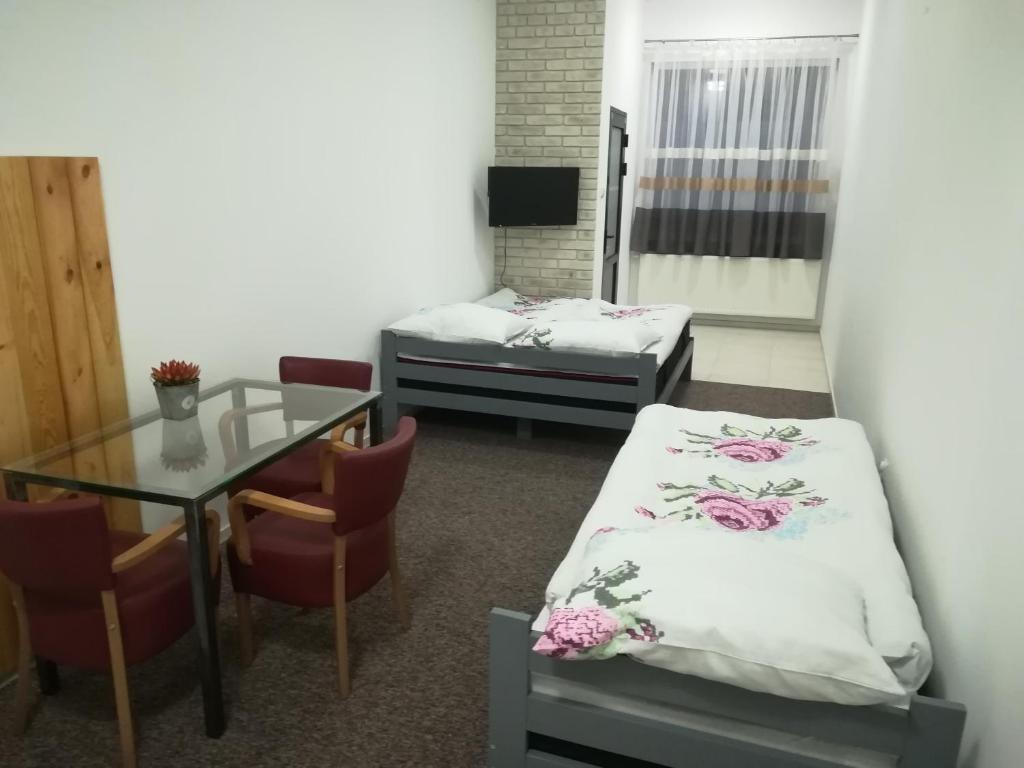Pokój z 2 łóżkami, biurkiem i stołem w obiekcie Buko apartamenty w Uniejowie
