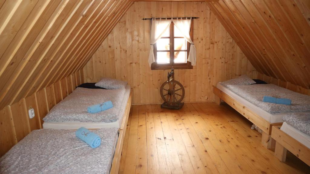 a room with two beds in a wooden cabin at penzion Drevenica in Šumiac