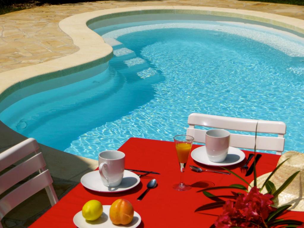 a table with food and drinks next to a swimming pool at Appartement dans Villa St Raphael in Saint-Raphaël