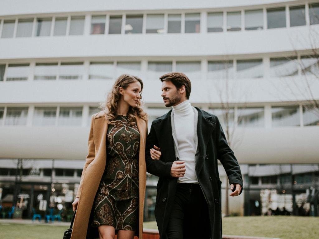 a man and a woman standing in front of a building at Empire Apart OVO in Wrocław