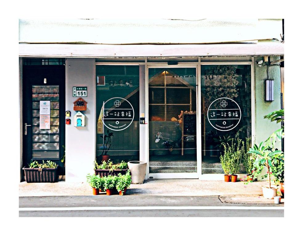 Happiness . danshui في تامسوي: واجهة متجر مع أبواب زجاجية ونباتات في الأمام