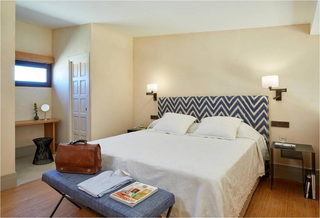 a bedroom with a large bed with a suitcase on a table at Trafalgar Polo Club in El Palmar