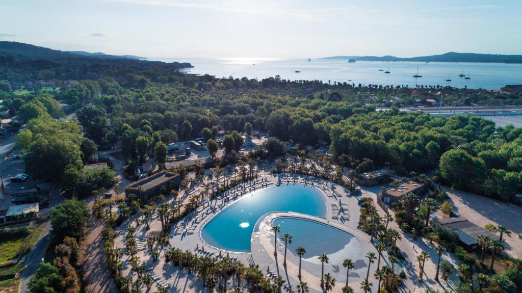 uma vista aérea de um parque com uma piscina e um lago em Marino Mobilhomes em Grimaud