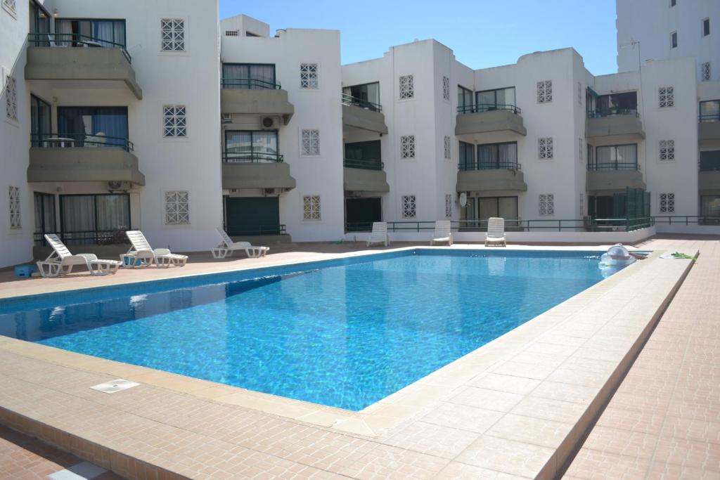 a swimming pool in front of a building at Algamar by Garvetur in Vilamoura