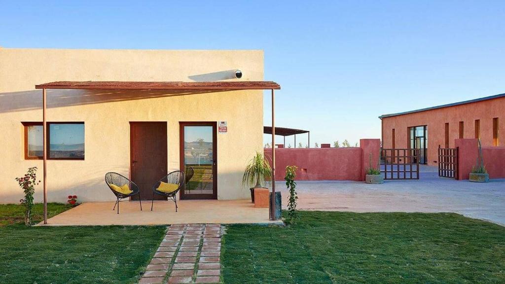 two chairs sitting in front of a house at Trafalgar Polo Club in El Palmar