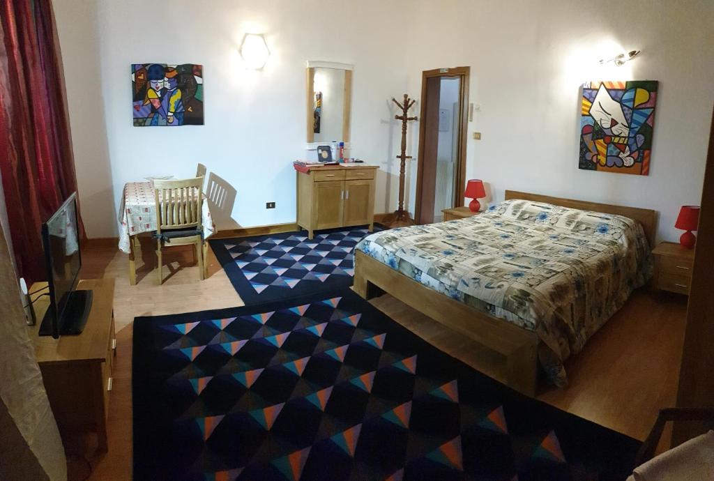 una camera con letto, tavolo e sedie di Appartamento La Chiocciola a Treviso