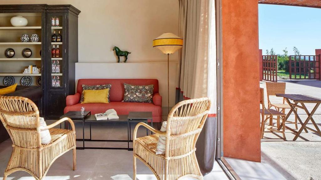 a living room with a red couch and two chairs at Trafalgar Polo Club in El Palmar