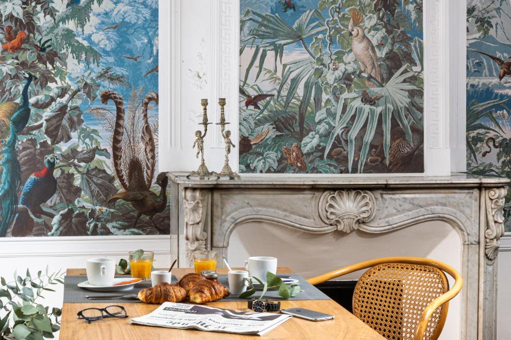 une salle à manger avec une table et une fresque murale. dans l'établissement Maison Dauphine, à Aix-en-Provence