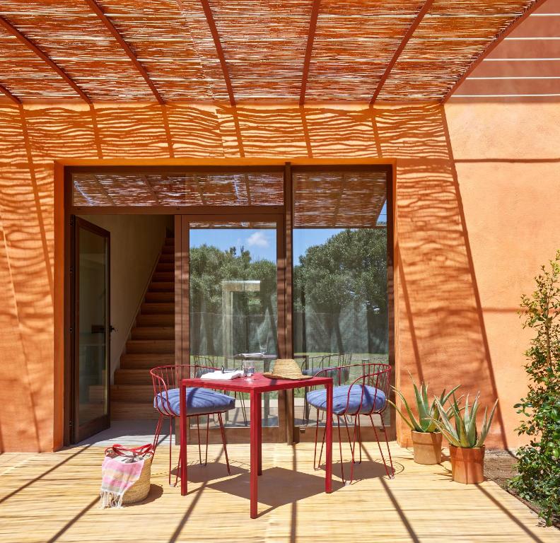 a patio with a table and chairs on a deck at Trafalgar Polo Club in El Palmar