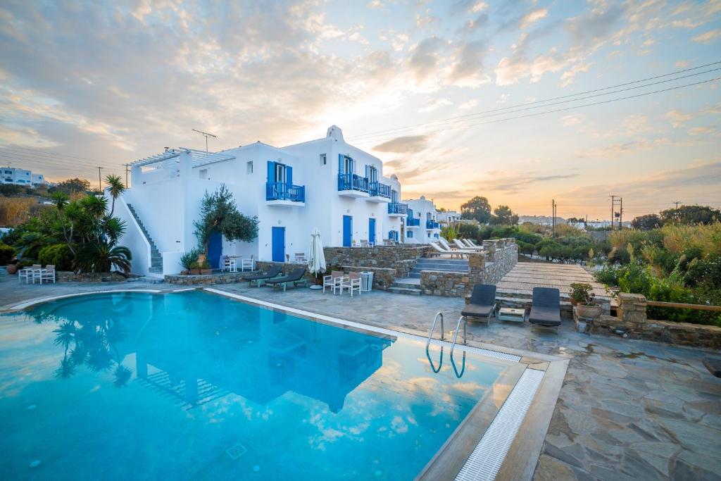 a villa with a swimming pool in front of a building at Vienoula's Garden Hotel in Mýkonos City