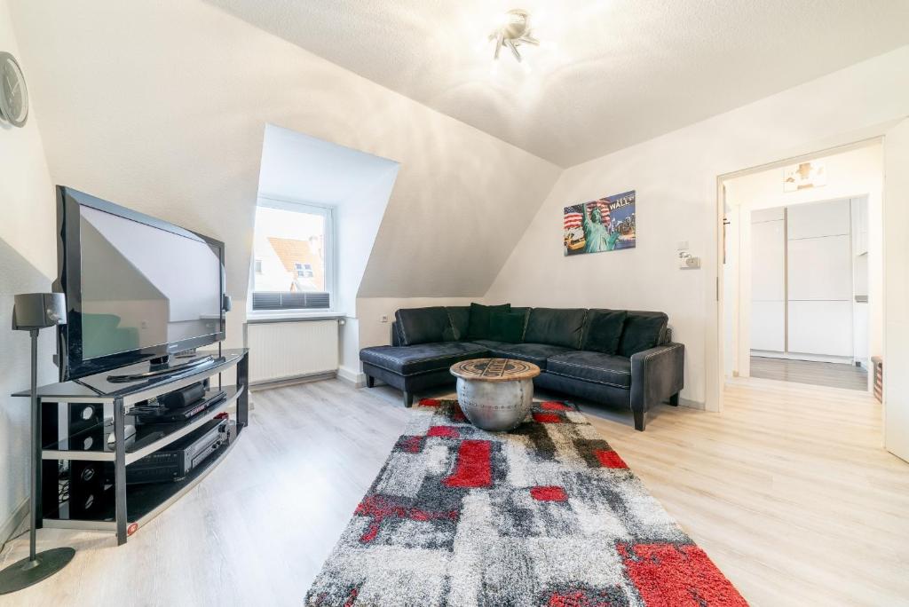 a living room with a couch and a tv at Private Apartment in Hannover