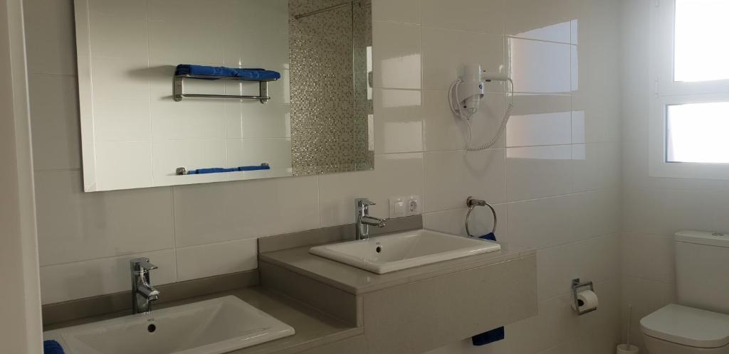biała łazienka z umywalką i toaletą w obiekcie Villa Rustica Gran Canaria w mieście Maspalomas