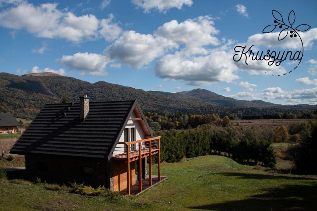 ein kleines Haus auf einem Hügel mit Bergen im Hintergrund in der Unterkunft Kruszyna - domek z widokiem na połoniny in Smerek