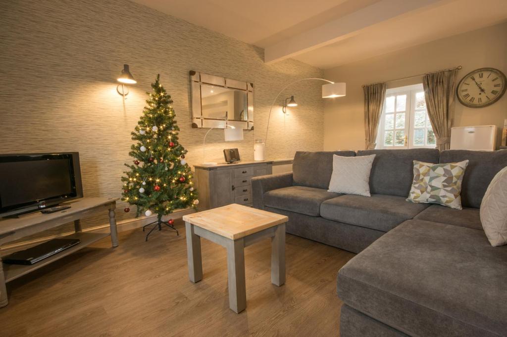 a living room with a christmas tree and a couch at Eyam Cottage - Darwin Lake Holiday Village in Matlock