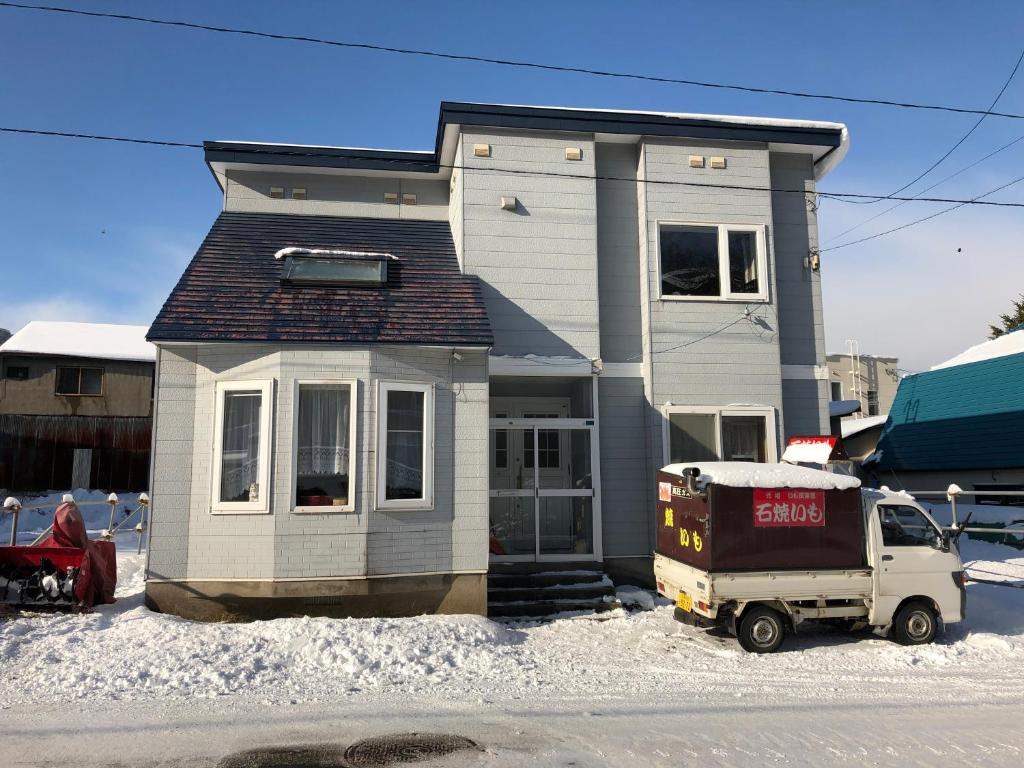 una casa con un camión aparcado delante de ella en Home Yasuda, en Otaru