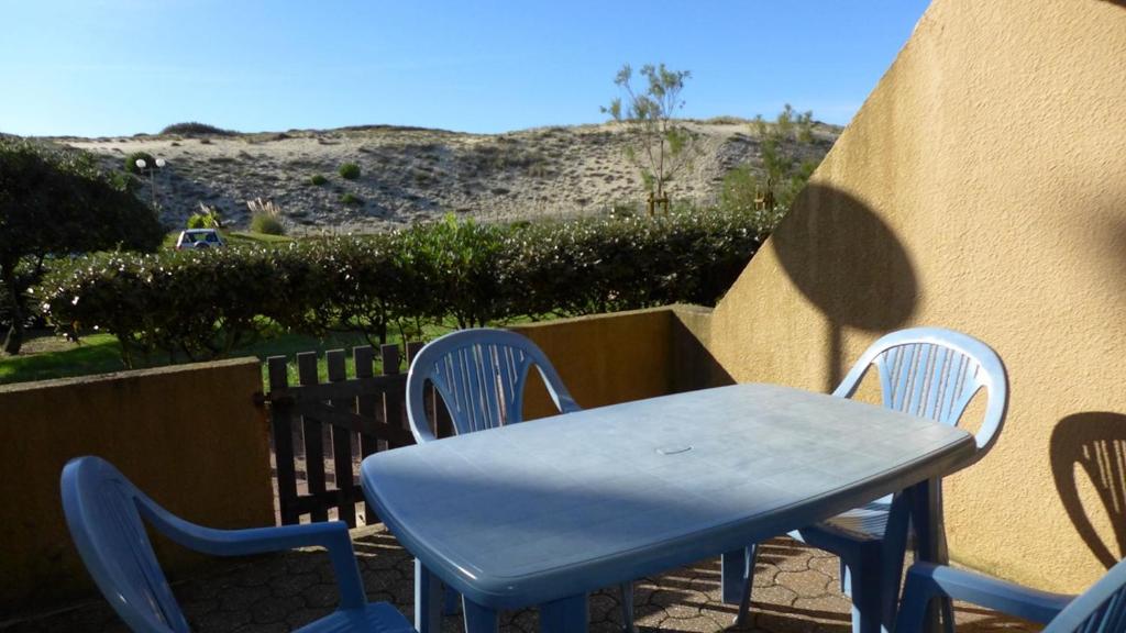 uma mesa azul e cadeiras sentadas num pátio em Réf 434 Seignosse océan, appartement classé 2 étoiles, accès direct à l'océan et place de parking privée, 4 personnes em Seignosse