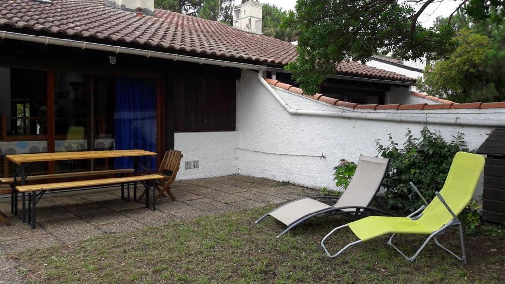 a patio with two chairs and a table and a bench at Réf 259, Seignosse océan, Villa Patio au calme, plage et commerces à proximité, 6 personnes in Seignosse