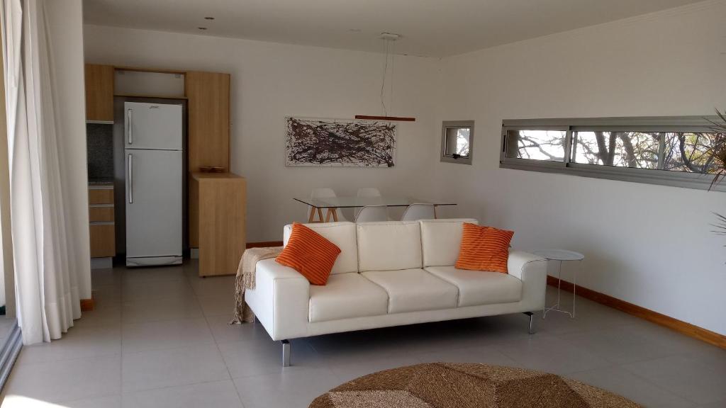 uma sala de estar com um sofá branco com almofadas laranja em Freyre 754 - Departamentos temporarios categoría em Rosário