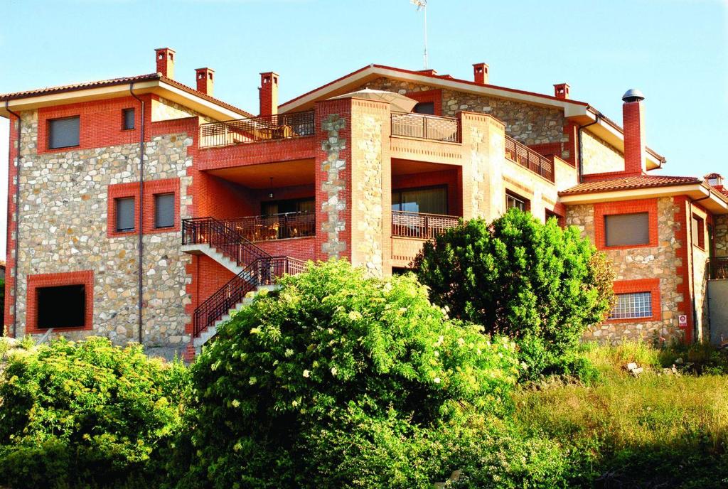 un gran edificio de ladrillo con árboles delante de él en La Becera, en Peñausende