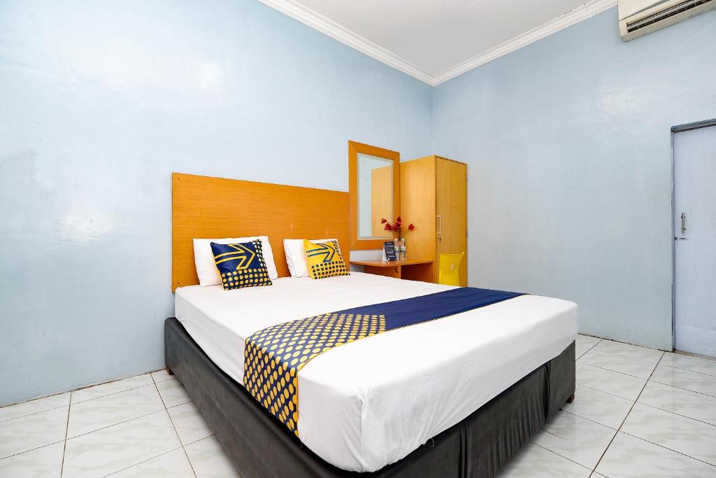 a bedroom with a large bed in a room at Griya Sakura Syariah in Solo