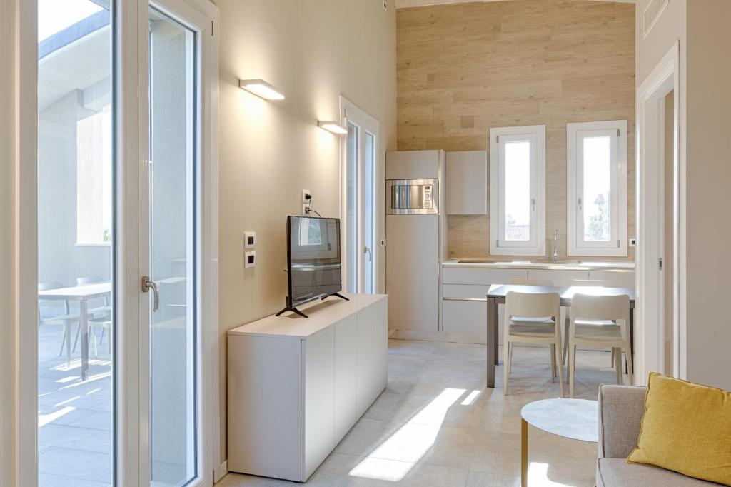Il comprend un salon avec une télévision et une cuisine. dans l'établissement Homingarda - fine holiday apartments, à Peschiera del Garda