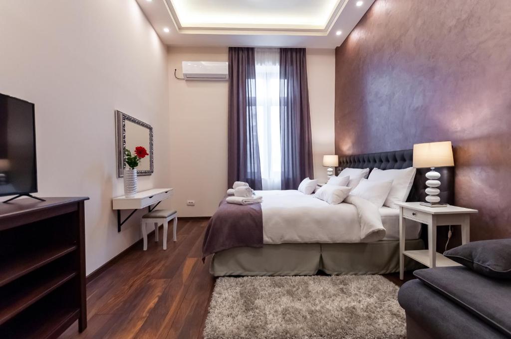 ein Schlafzimmer mit einem großen Bett und einem TV in der Unterkunft Mala Sava Apartmani in Belgrad