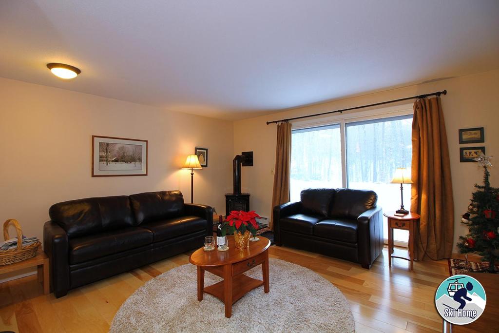 - un salon avec deux canapés en cuir et une table dans l'établissement Cozy one bedroom Edgemont B3 condo ski back trail, à Killington