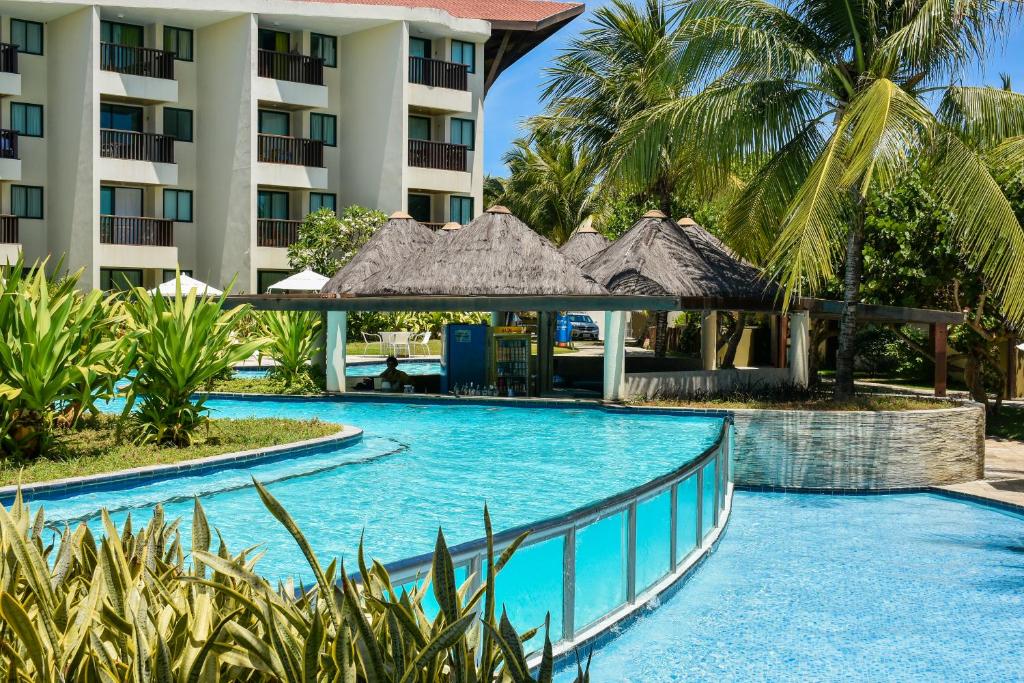 a swimming pool in front of a hotel at Muro Alto Marulhos in Porto De Galinhas