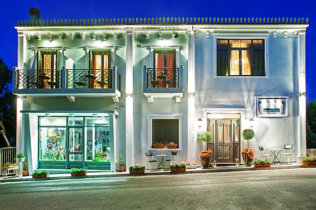 a white building with windows and plants on it at Archontiko Kymis Boutique Hotel in Kymi