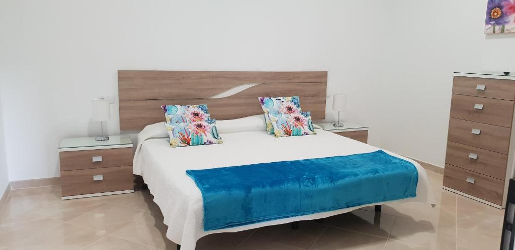 sypialnia z dużym łóżkiem i dwoma szafkami nocnymi w obiekcie Villa Rustica Gran Canaria w mieście Maspalomas