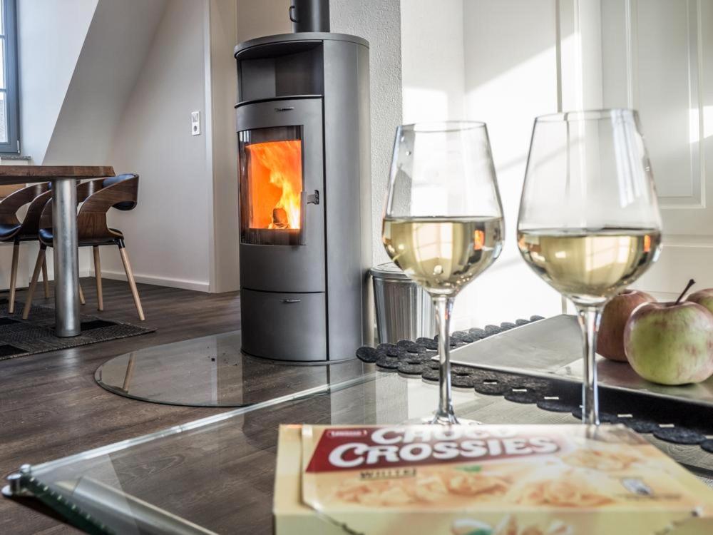ヴェルニゲローデにあるLuxuriös Ferienwohnung über Wernigerodeの暖炉のそばでの白ワイン2杯