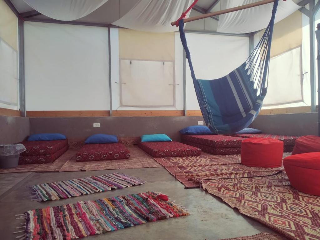 um quarto com almofadas vermelhas e azuis e uma rede de descanso em Sinai Bagolan em Giv'at Yo'av