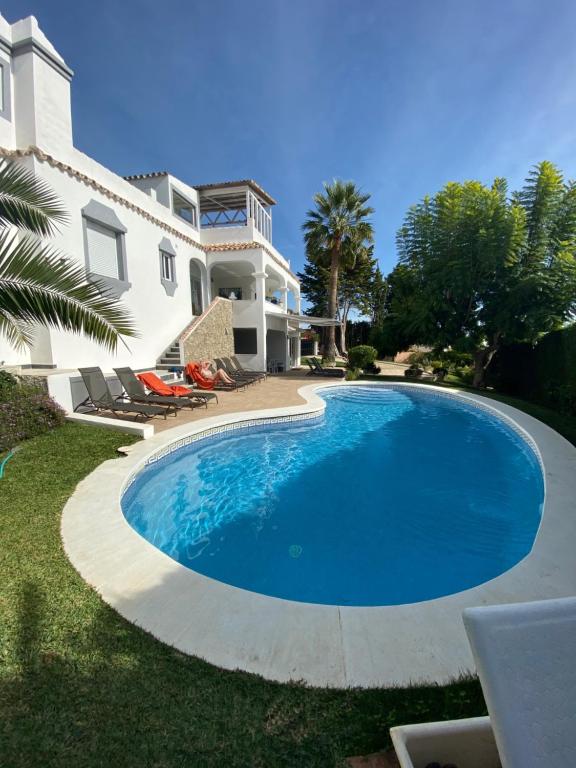 a swimming pool in front of a house at Luxury Villa Marbella with nice garden, Pool and Jacuzzi BY Varenso Holidays in Marbella