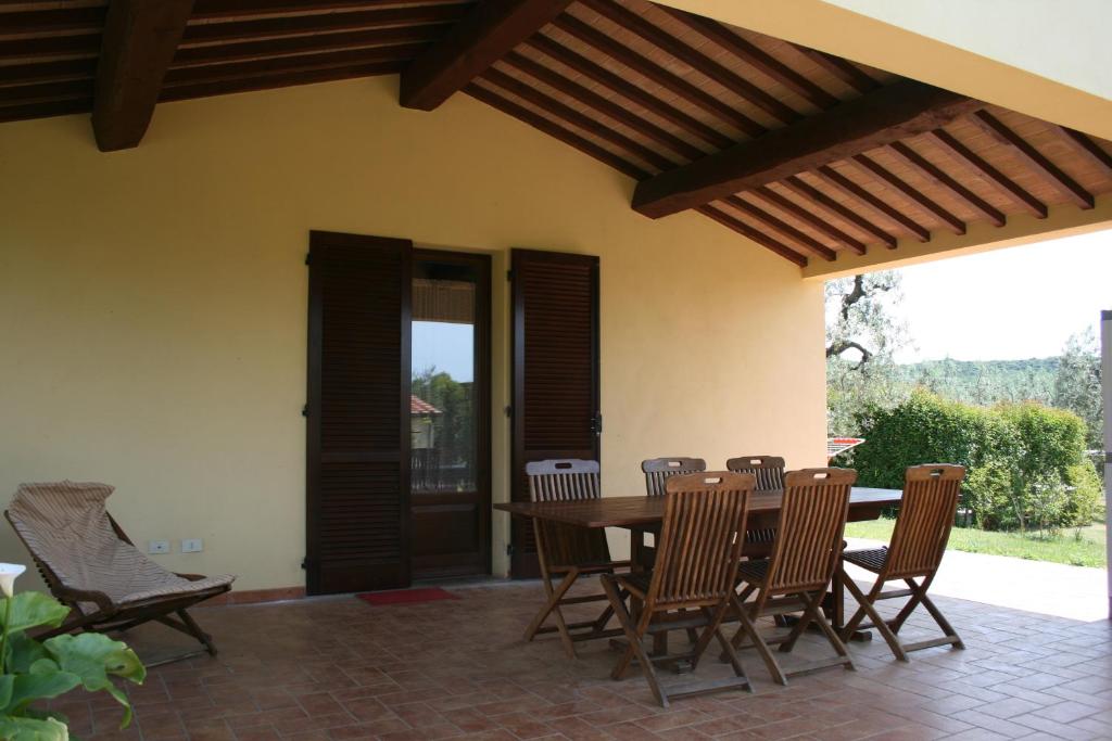 un patio con tavolo e sedie in legno di Graziosa casetta con Piscina a Castagneto Carducci