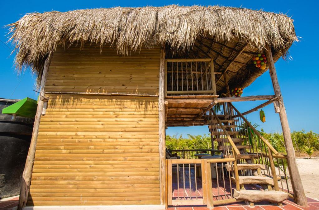 une petite cabane avec un toit de chaume et un escalier dans l'établissement Cabañas El Arca, à Tierra Bomba